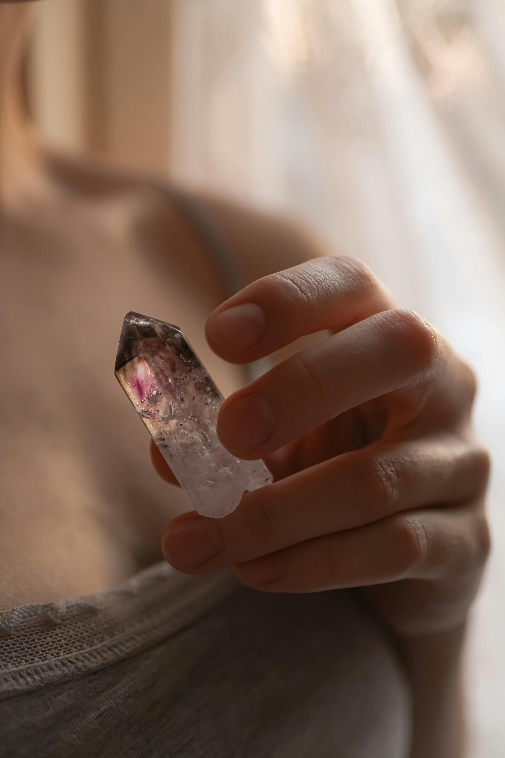 Crystal connection hand holding a feminine healing crystal for heart healing